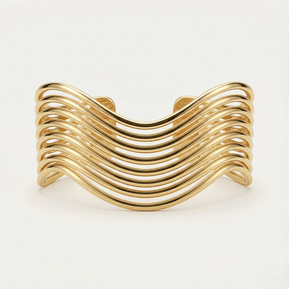 Gold bracelet with wavy design on a white background