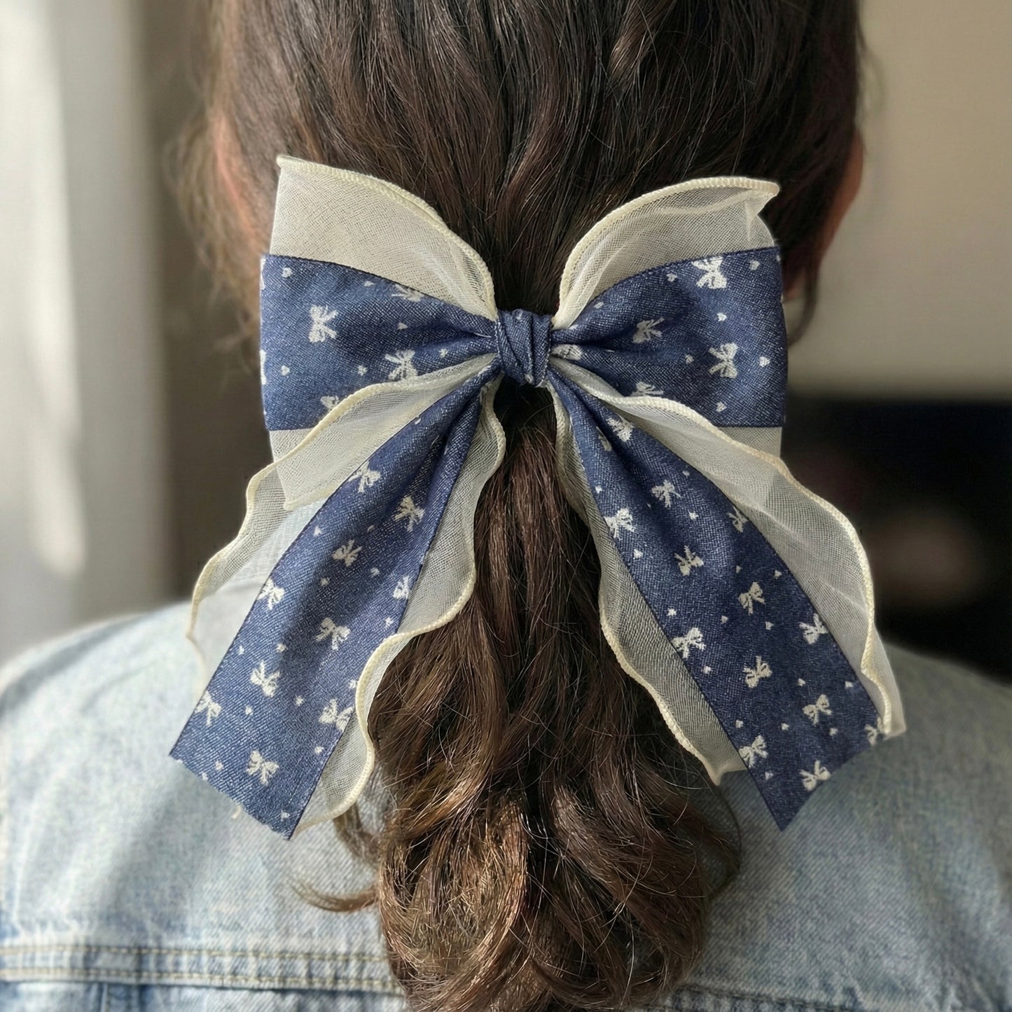 Large blue and white polka dot bow in a person's hair