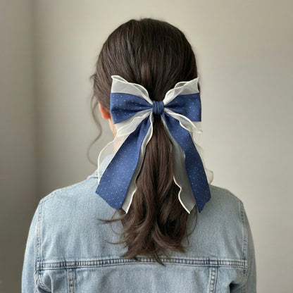 Person with a large blue and white bow in their hair 