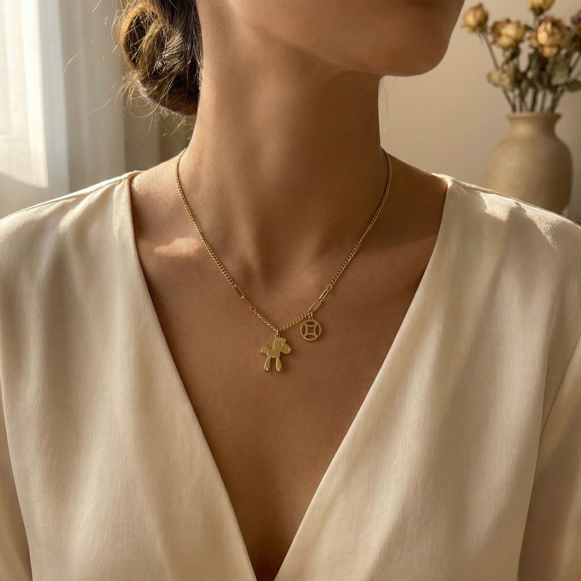 Gold necklace with a pendant worn by a person in a neutral setting