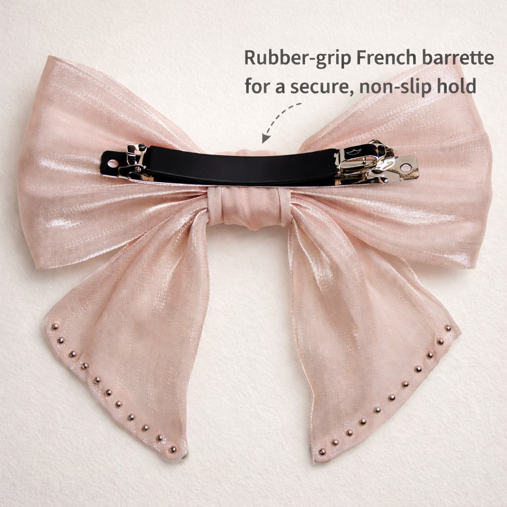 Pink bow hair clip with black rubber-grip French barrette on a light background