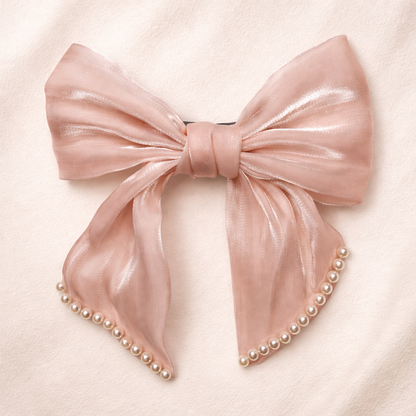 Pink bow hair clip with pearls on a light pink background