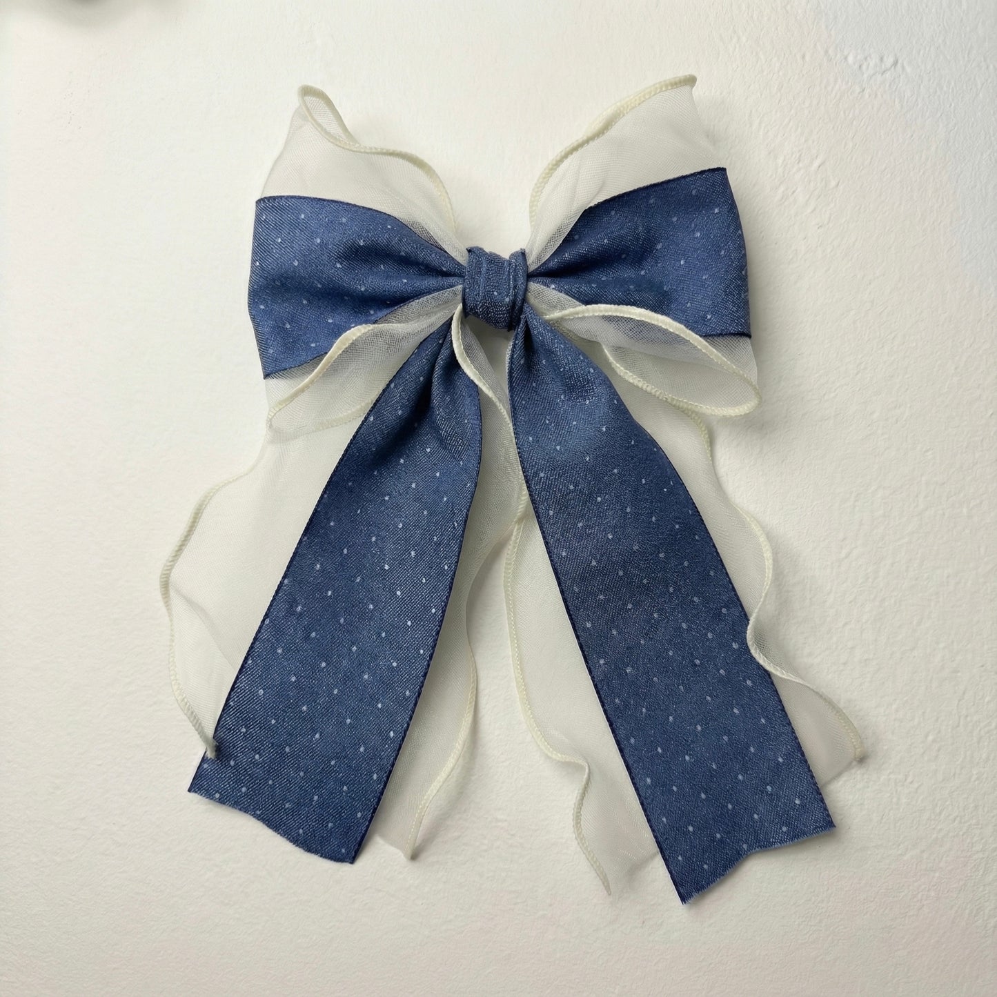 Blue and white decorative bow on a textured white background