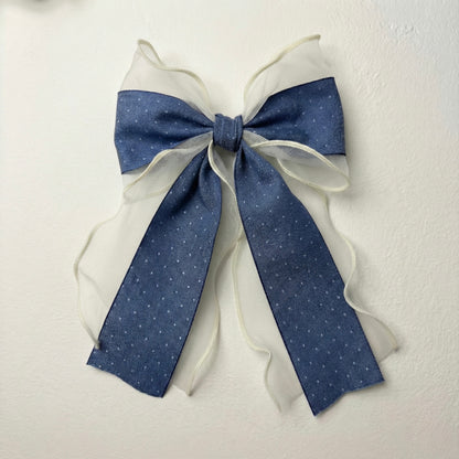 Blue and white decorative bow on a textured white background
