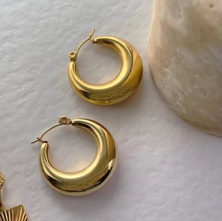 Gold hoop earrings on a light background