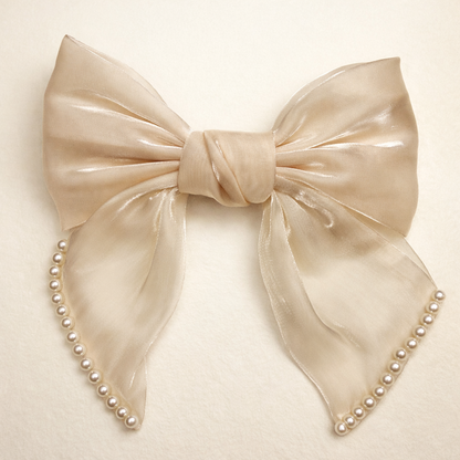 Large beige bow with pearl accents on a light beige background