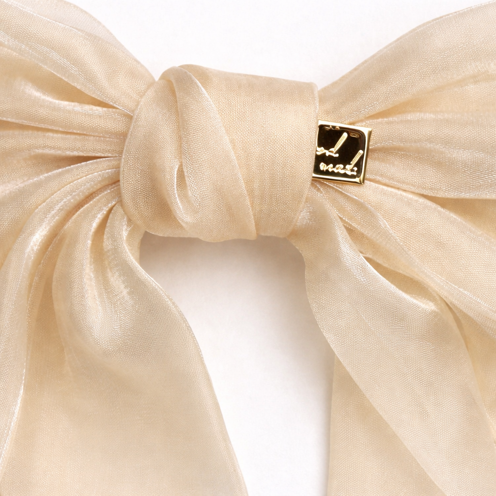 Beige bow with a gold tag on a white background