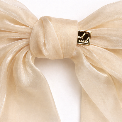 Beige bow with a gold tag on a white background